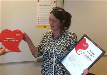 Kristin Halås mottar beviset for at Averøy sykehjem er sertifisert som Livsgledesykehjem - Klikk for stort bilde